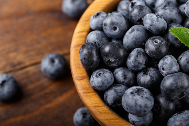 新鲜采摘的蓝莓放在木碗里。图片下载