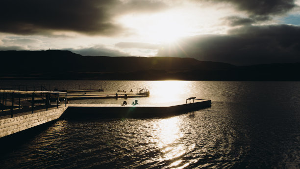 风景优美的夏日日落在峡湾与热水池在冰岛图片下载
