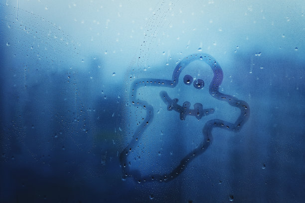 蓝色背景的窗户玻璃上画着欢快的幽灵图片下载