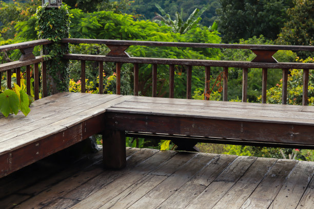 木制阳台上有一张带靠背的木凳。图片下载