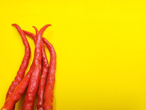 黄色背景上的几根红辣椒图片下载