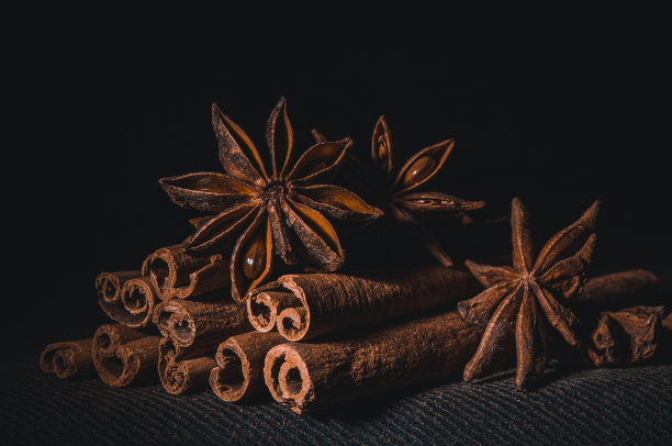圣诞烘焙香料，肉桂棒和八角星为圣诞蛋糕，饼干或热葡萄酒在黑色背景，微距照片图片下载