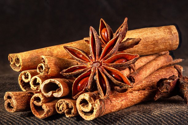 圣诞烘焙香料，肉桂棒和八角星为圣诞蛋糕，饼干或热葡萄酒在黑色背景，微距照片图片下载