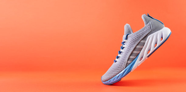 稳定性和缓冲跑鞋。新的无品牌跑步运动鞋或训练在橙色背景。男人的运动鞋类。图片下载