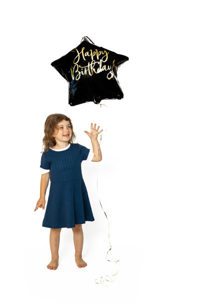 可爱的白人女孩4-5岁，带着黑色星形凝胶气球，上面写着生日快乐。照片在工作室对白色背景图片下载