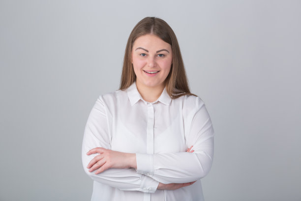 快乐的大码女人。开朗的超重年轻女性穿着正式的白衬衫在工作室。年轻的成人模型表达积极和好心情图片下载