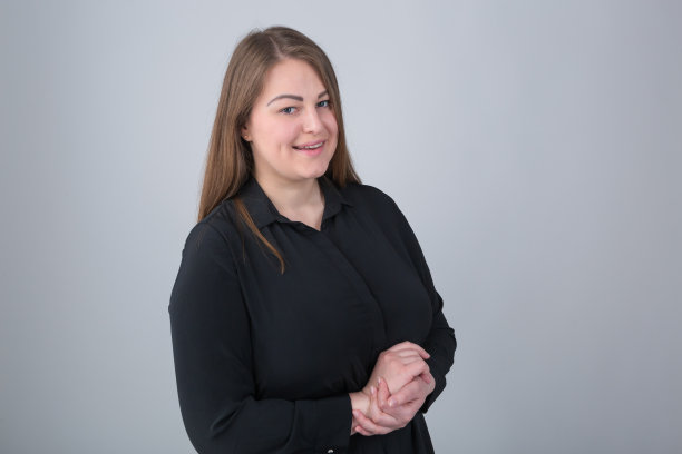 微笑的年轻超重的女人在摄影棚里穿着黑衬衫摆姿势。加上尺寸的模特肖像心情好。30多岁的快乐女性，超重，带着顽皮的微笑看着镜头图片下载