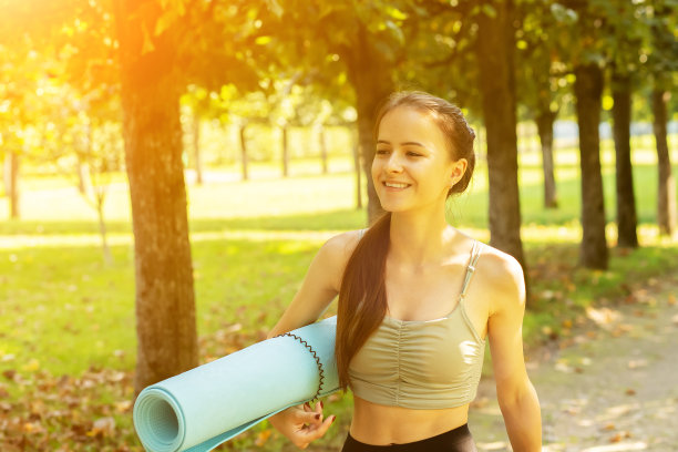 青少年在大自然中训练，年轻的运动女性在公园里用瑜伽垫做运动和健身锻炼，健康的生活方式图片下载