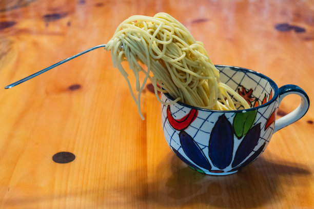 泡面在杯子里飘飞，叉子悬在半空中图片下载