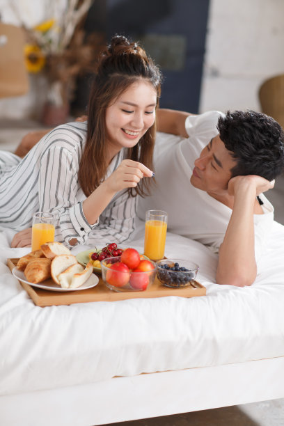 青年情侣在床上吃早餐图片下载