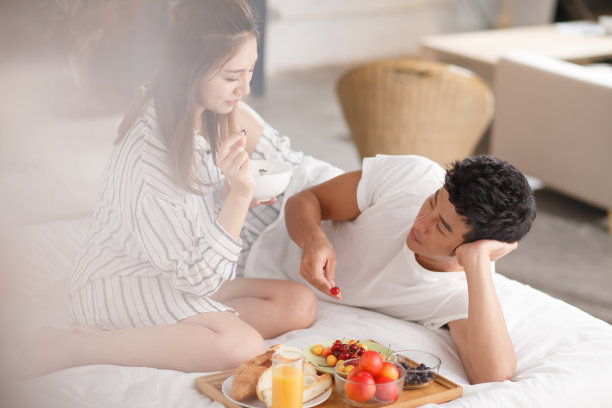 青年情侣在床上吃早餐图片下载