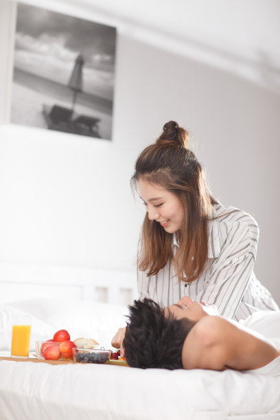 青年情侣在床上吃早餐图片下载
