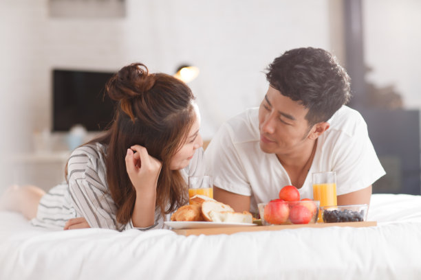 青年情侣在床上吃早餐图片下载