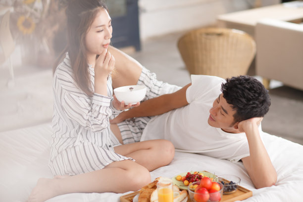 青年情侣在床上吃早餐图片下载