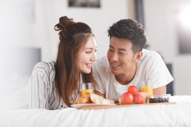 青年情侣在床上吃早餐图片下载