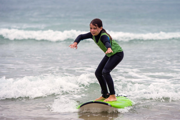 可爱的年轻女孩正在上冲浪课图片下载