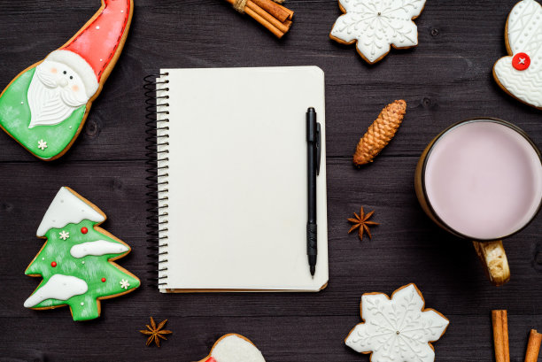 打开空白的笔记本，自制的姜饼饼干和一杯可可放在深色木桌上。俯视图，平躺。圣诞节的背景。新年决心，目标，自由空间图片下载