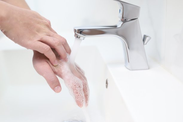 一个人在水槽里洗手。阻止病毒的传播经常用肥皂洗手。用人类香皂洗手可以预防冠状病毒。图片下载