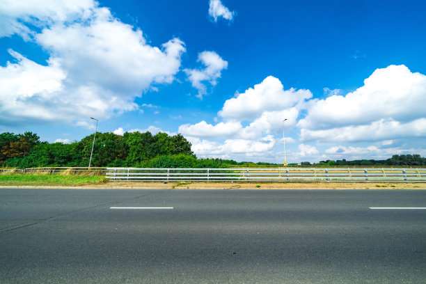 蓝天下的柏油路和绿色森林图片下载