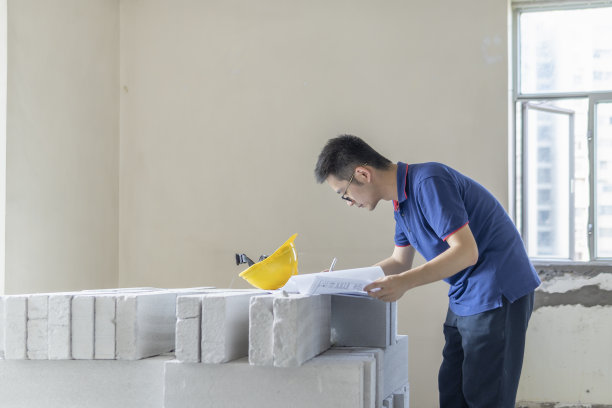 亚洲男性工程师在装修工地处理施工图纸图片下载