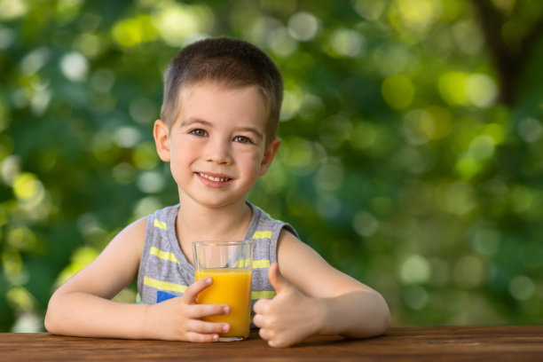 小男孩拿着果汁，竖起大拇指图片下载
