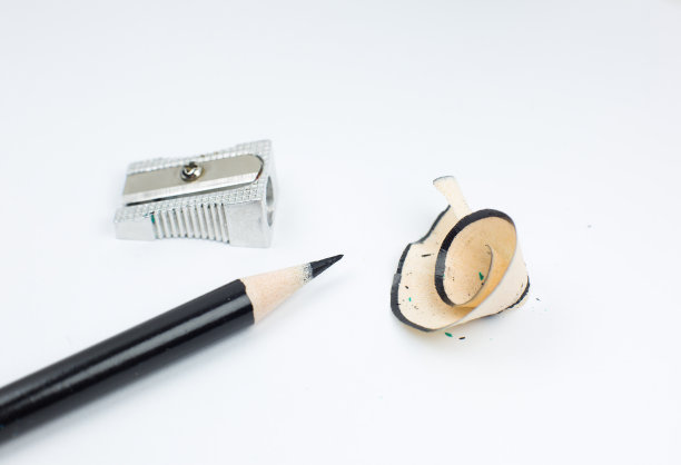 卷笔刀和断了的铅笔。白色背景上的刨花和石墨。特写，微距照片。回到学校的概念。图片下载