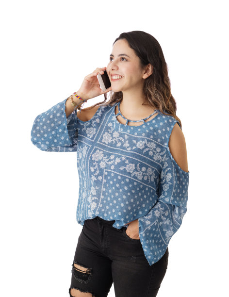 快乐的年轻女人站着微笑着讲电话图片下载