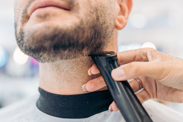 剪发师的手在沙龙给一个男人刮胡子的裁剪照片图片下载