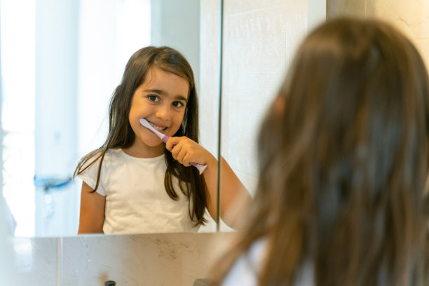 小女孩早上在家里刷牙的时候对自己微笑图片下载