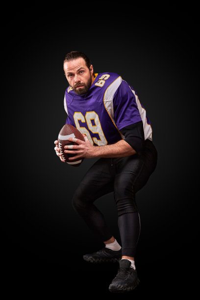 美国足球运动员的肖像投掷球在黑色的背景图片下载