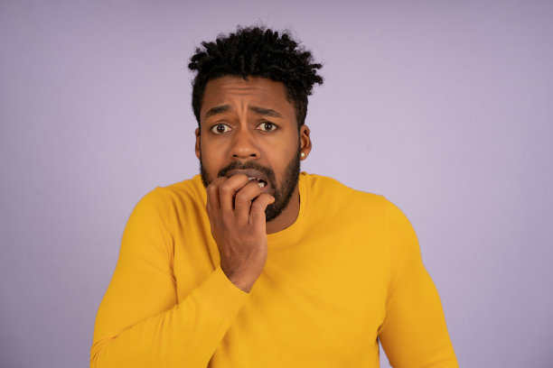 用手捂住嘴的吓坏了的非洲男人。图片下载