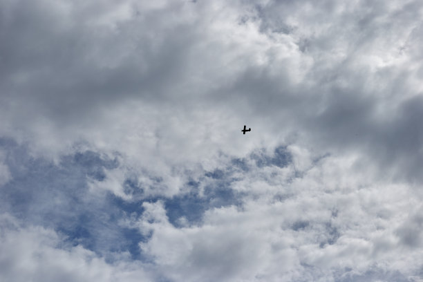 一架小型运动飞机载着云朵飞过天空图片下载