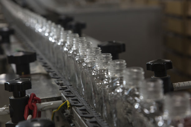 工厂生产线上一排排塑料瓶，水平特写。图片下载