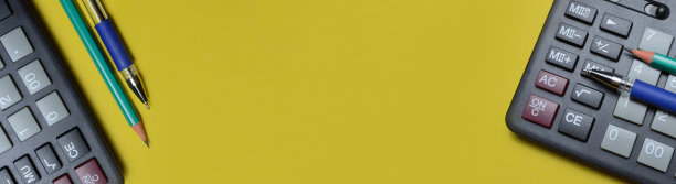 黄色背景上的计算器铅笔和钢笔。特写镜头。漫长的旗帜。图片下载
