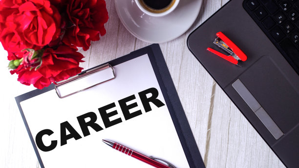 “事业”这个词写在白色记事本上，旁边是红玫瑰和电脑。经营理念图片下载