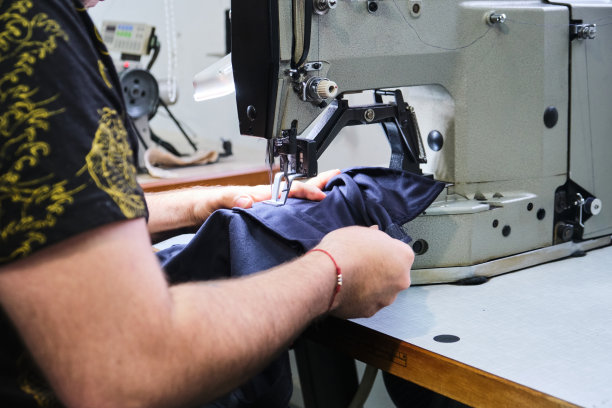 一个不认识的人使用缝纫机的手的裁剪视图图片下载