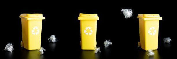 垃圾桶设置。黄色的垃圾桶用于回收塑料、纸张和玻璃垃圾，被隔离在黑色背景上。容器处理垃圾废物，节约环境。图片下载