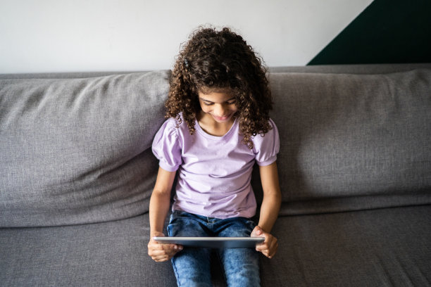 女孩在家里使用电子平板电脑图片下载