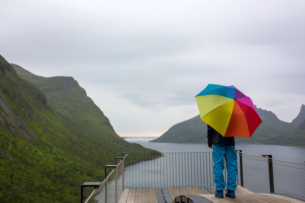 孩子，站在44米长的观景台的边缘，俯瞰Bergsfjord的水，享受挪威Senja岛的景色图片下载