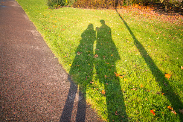 地上男人和女人的长长的影子图片下载