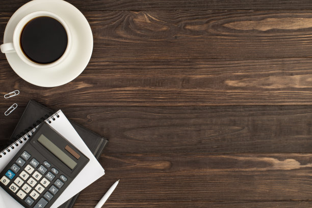 顶视图照片的咖啡杯在碟子白色剪辑笔和计算器在两个规划师孤立的暗木桌背景与空的空间图片下载