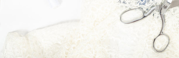 裁剪。服装设计。剪裁婚纱的概念。白色刺绣织物和剪刀图片下载