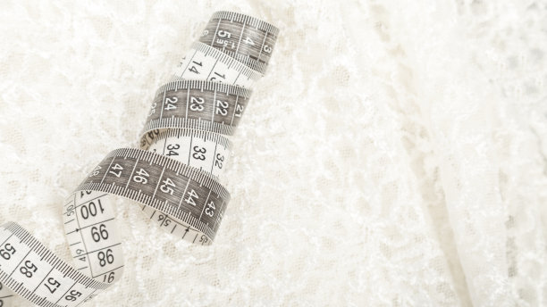 裁剪的概念。缝纫和针线活用的配件。白色刺绣织物和卷尺。背景图片下载