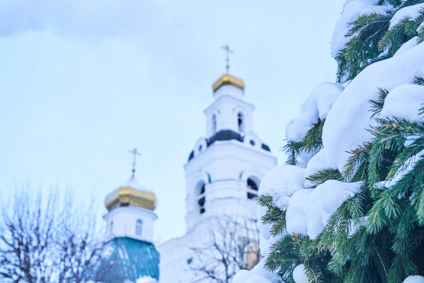 这是东正教教堂镀金的上部，背景是蓝天和白雪覆盖的冷杉树枝。圣诞节的背景。空间复制图片下载