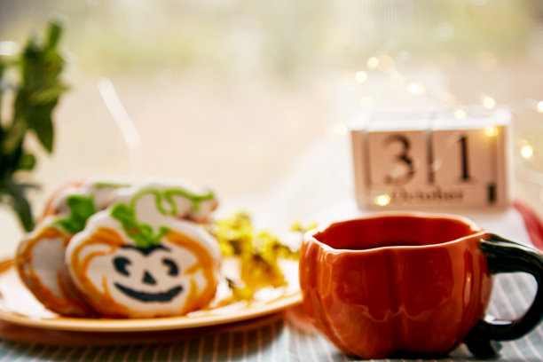 快乐的万圣节静物南瓜杯和自制的可爱的南瓜形状的饼干和万圣节的日期。大气美学的秋季假日概念。乡村生活图片下载