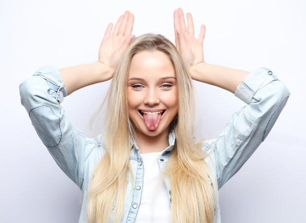 生活方式和人的概念:看着我，好像我很有趣。一个年轻美丽的女孩的肖像在白色的背景与一个微笑显示喇叭在相机图片下载