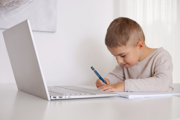 小男孩在家用笔记本电脑学习。儿童用电脑做作业的画像。在线教育和电子学习概念。居家隔离远程学习。现代儿童与教育技术。图片下载