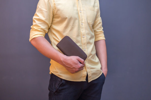 一个男人手里拿着棕色的皮夹图片下载