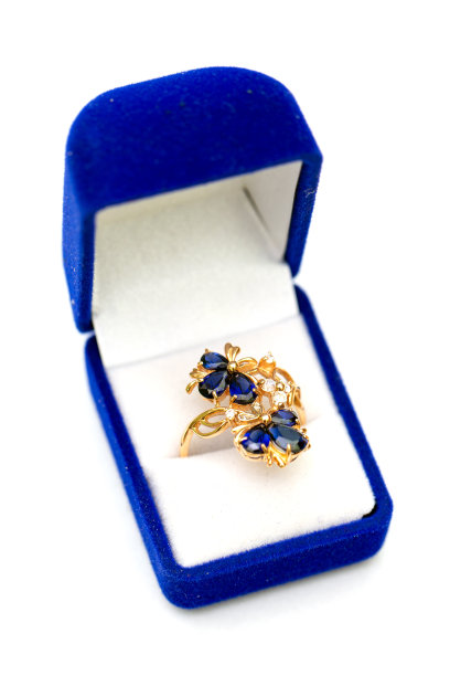 金戒指与蓝色蓝宝石和立方锆石在礼盒白色背景图片下载