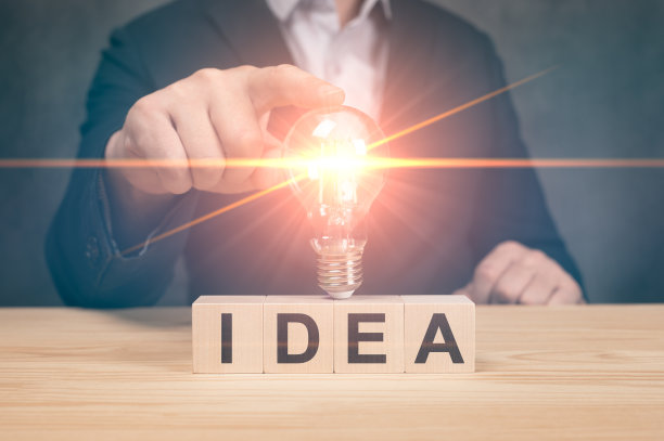 商人摸着一个明亮的灯泡。创意概念，呈现新创意伟大的灵感和创新的新开端。19、观念新思想，具有创新和创造力图片下载